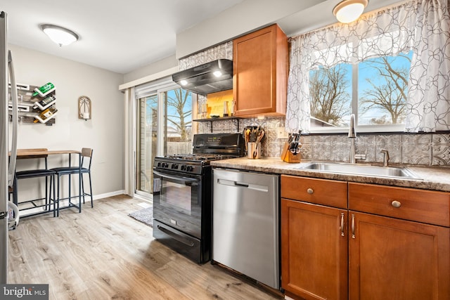 kitchen featuring extractor fan, a sink, stainless steel dishwasher, brown cabinetry, and black gas range oven