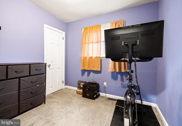 workout room featuring baseboards and carpet flooring