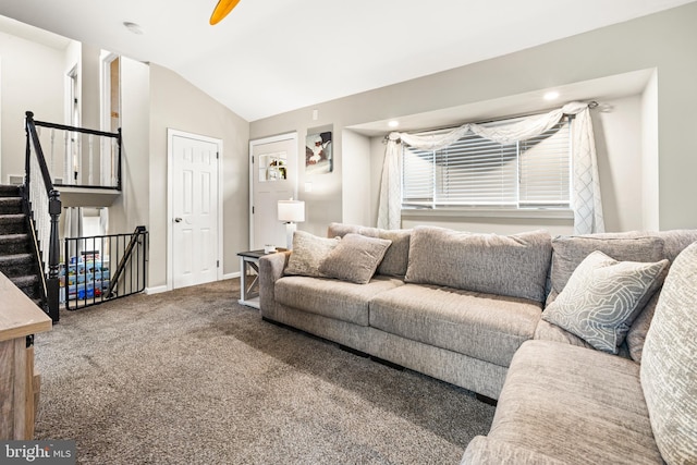 carpeted living room with vaulted ceiling, stairway, and baseboards