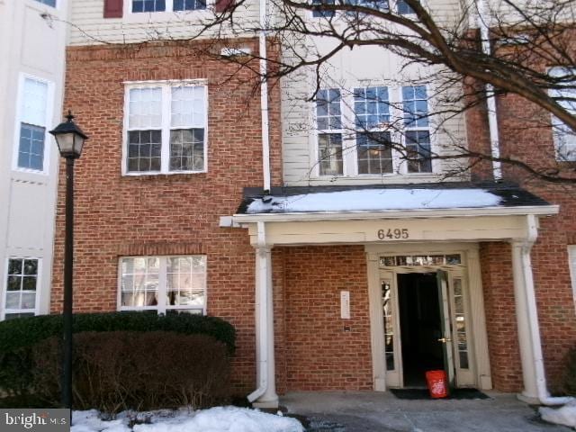 view of exterior entry featuring brick siding