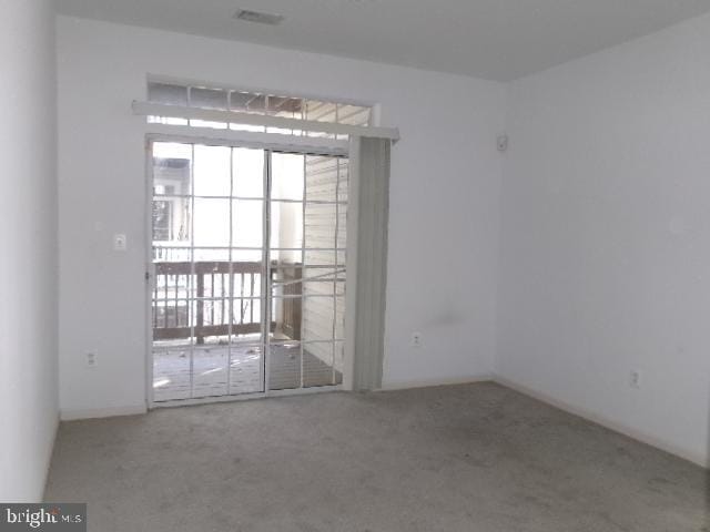 unfurnished room featuring carpet floors and visible vents