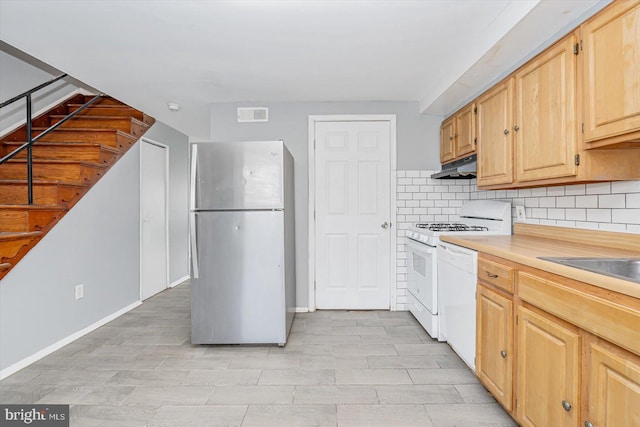 kitchen featuring light countertops, white appliances, light brown cabinets, and under cabinet range hood