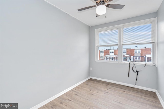 unfurnished room featuring a ceiling fan, baseboards, and light wood finished floors