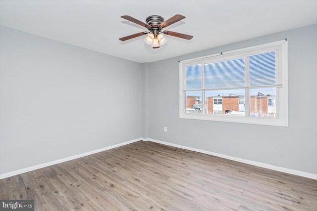 empty room featuring a ceiling fan, baseboards, and wood finished floors