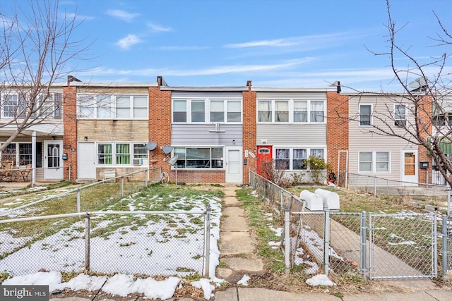 view of front of home featuring a fenced front yard, a gate, and brick siding