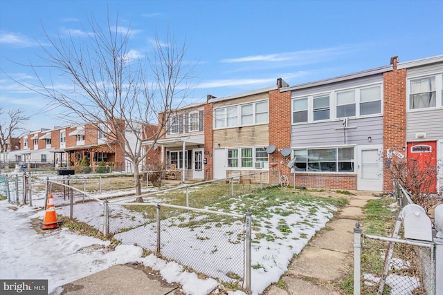 rear view of property with a fenced front yard, a residential view, a gate, and brick siding