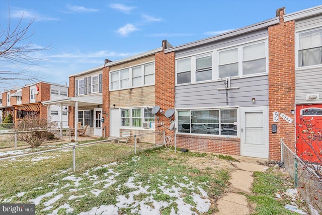 back of property with brick siding and a fenced backyard