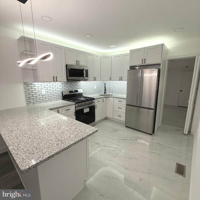 149 N 58th St, Philadelphia, PA 19139 - kitchen with light stone counters, marble finish floor, visible vents, appliances with stainless steel finishes, and a peninsula