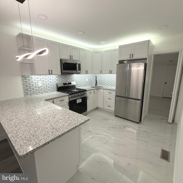 kitchen with light stone counters, marble finish floor, visible vents, appliances with stainless steel finishes, and a peninsula