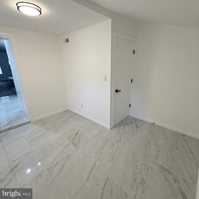 spare room featuring marble finish floor, visible vents, and baseboards