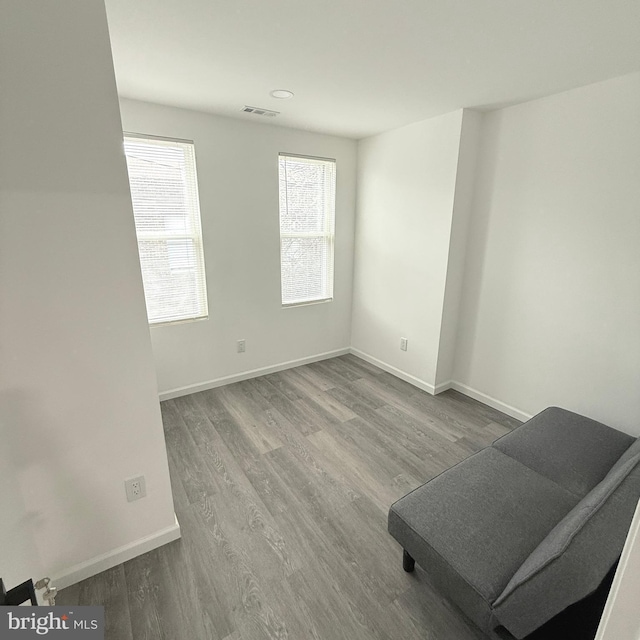 spare room with visible vents, baseboards, and wood finished floors