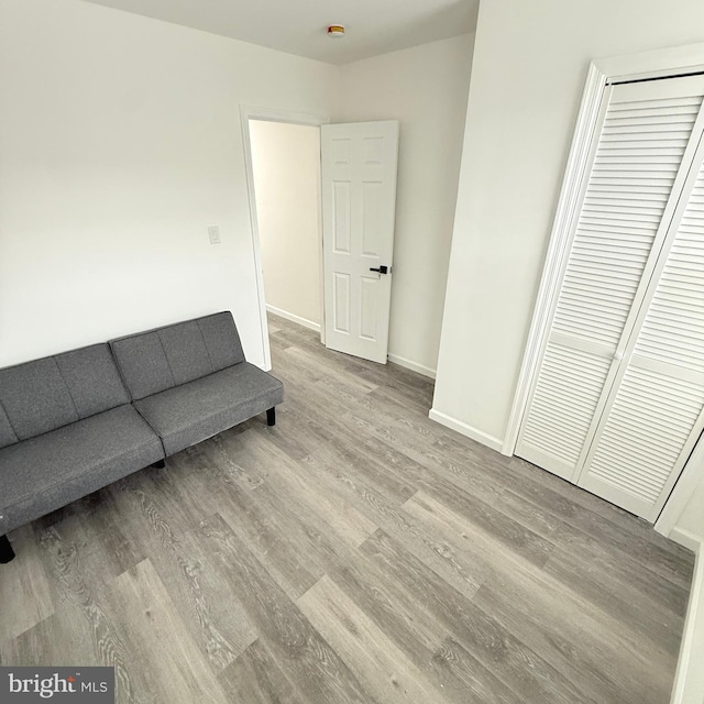 sitting room with baseboards and wood finished floors