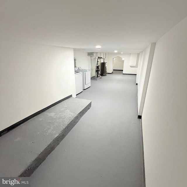 finished basement with gas water heater, washing machine and clothes dryer, and baseboards