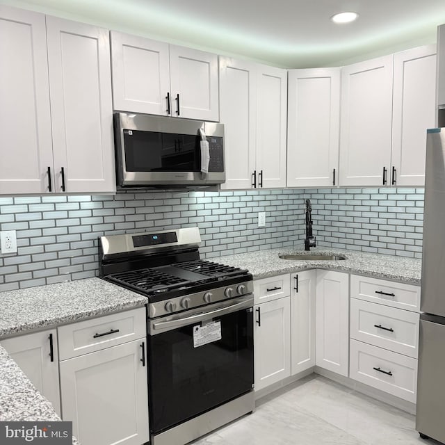 kitchen with white cabinets, stainless steel appliances, and a sink