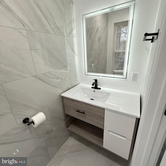 bathroom featuring vanity and tile walls