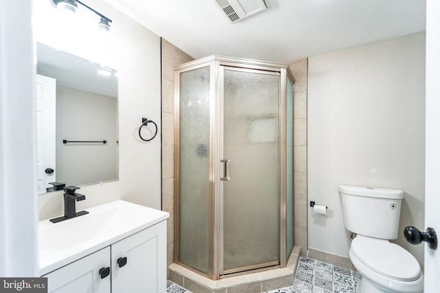 full bathroom with vanity, a shower stall, toilet, and visible vents