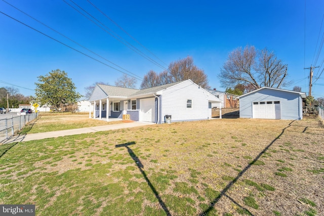 back of house with a detached garage, a lawn, an outdoor structure, and fence