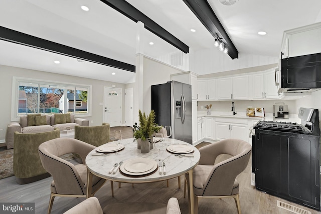 dining area featuring lofted ceiling with beams, recessed lighting, and light wood-style floors