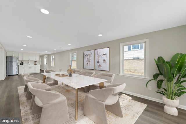 dining area with dark wood-type flooring, recessed lighting, a healthy amount of sunlight, and baseboards