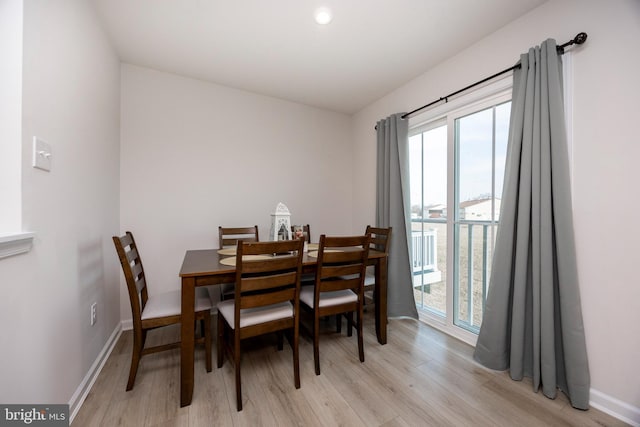 dining area featuring baseboards and light wood finished floors