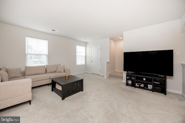 living area featuring carpet floors, baseboards, and visible vents