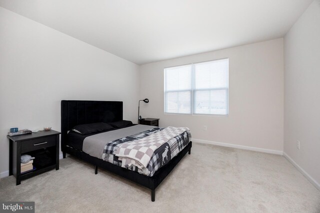 bedroom featuring baseboards and light colored carpet