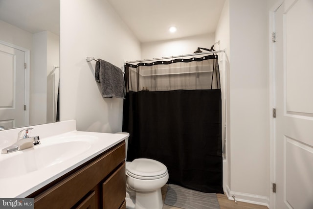 full bath featuring toilet, vanity, and curtained shower
