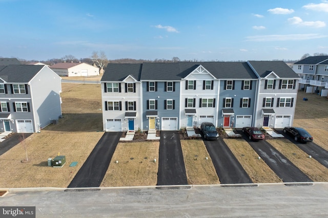 view of front of house featuring a residential view, driveway, and a garage