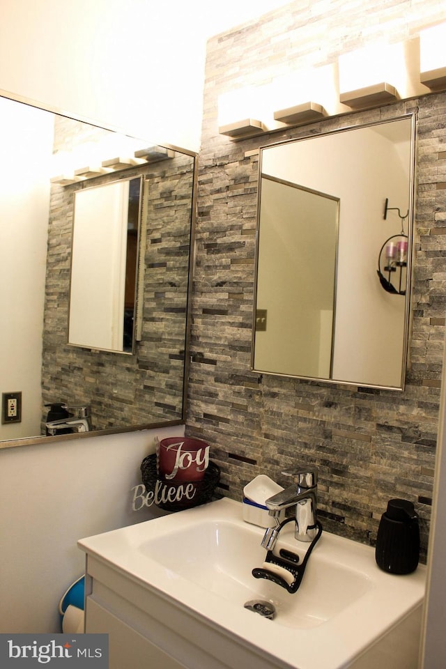 bathroom with tasteful backsplash and vanity