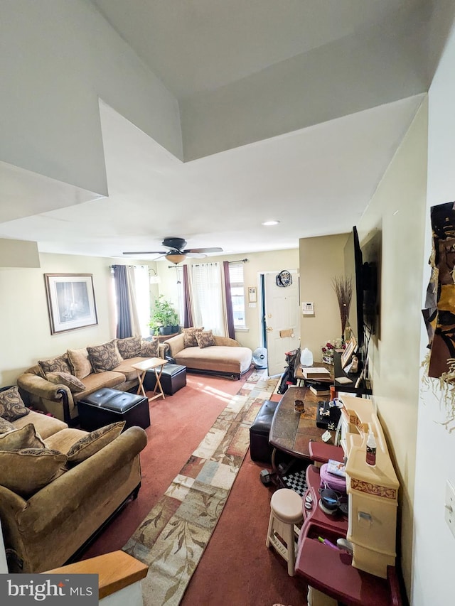 carpeted living area with a ceiling fan