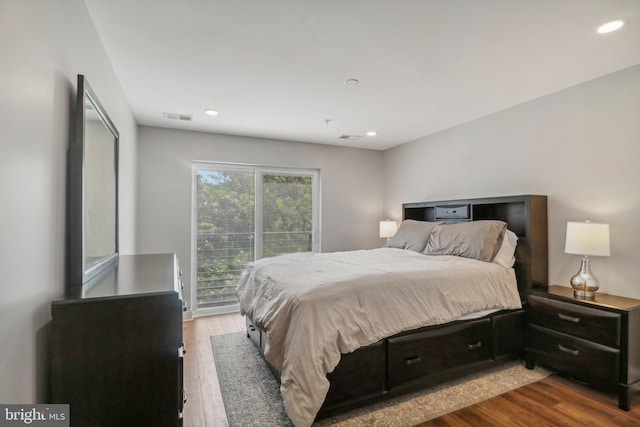 bedroom with access to exterior, visible vents, wood finished floors, and recessed lighting