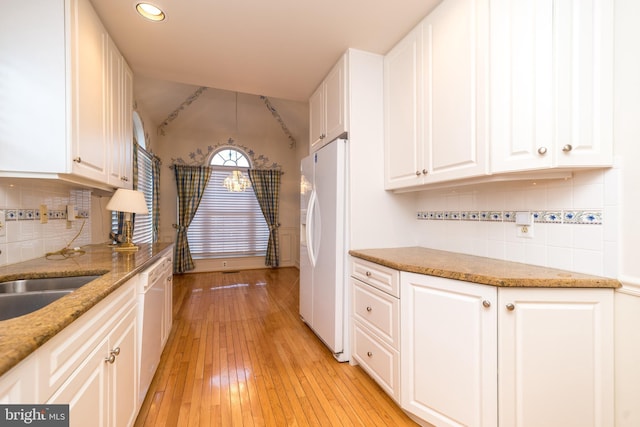 kitchen with light stone counters, white appliances, white cabinetry, and light wood-type flooring