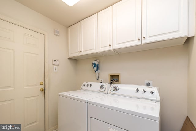 washroom featuring cabinet space and washer and clothes dryer