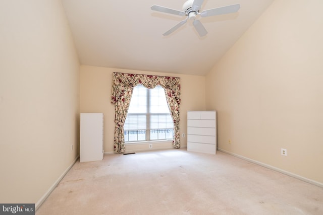 carpeted empty room featuring baseboards, lofted ceiling, and ceiling fan