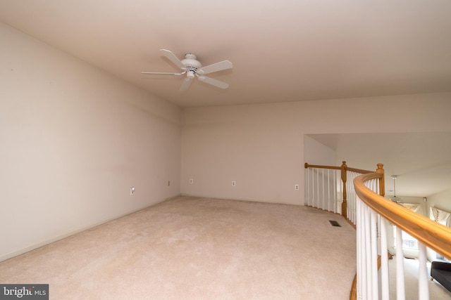 spare room with visible vents, light colored carpet, and ceiling fan