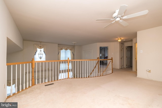 spare room featuring visible vents, a ceiling fan, and carpet floors