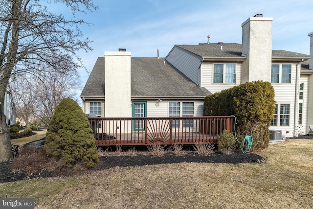 rear view of house featuring central AC unit, a chimney, a deck, and a shingled roof