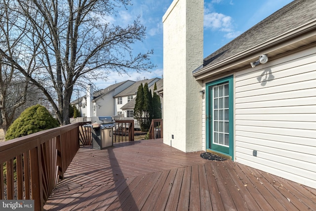 wooden terrace featuring a residential view and grilling area