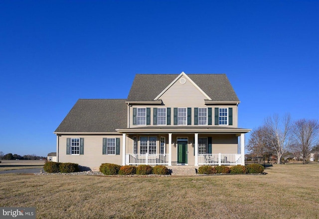 colonial house featuring covered porch and a front yard