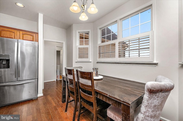 dining space featuring an inviting chandelier, baseboards, and dark wood-style flooring