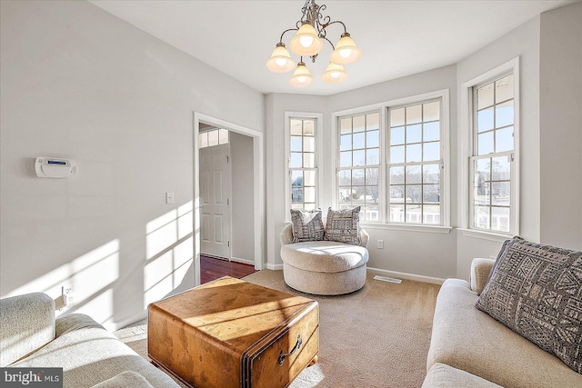 carpeted living area featuring an inviting chandelier, visible vents, and baseboards