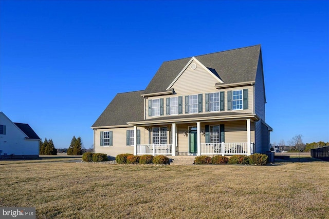 colonial inspired home featuring a porch, a front lawn, and fence