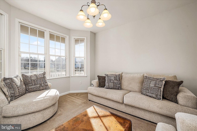 carpeted living room featuring baseboards and a notable chandelier