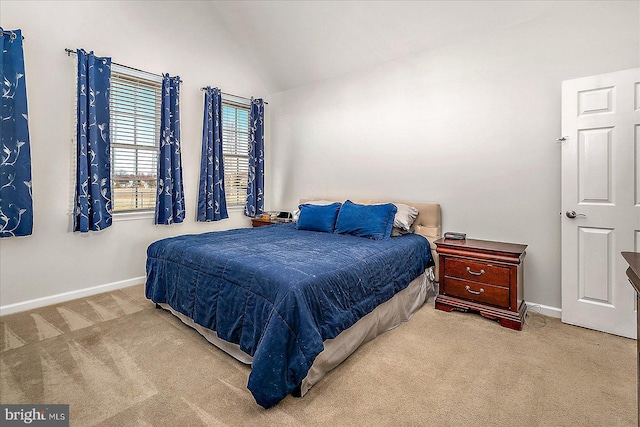 carpeted bedroom featuring lofted ceiling and baseboards