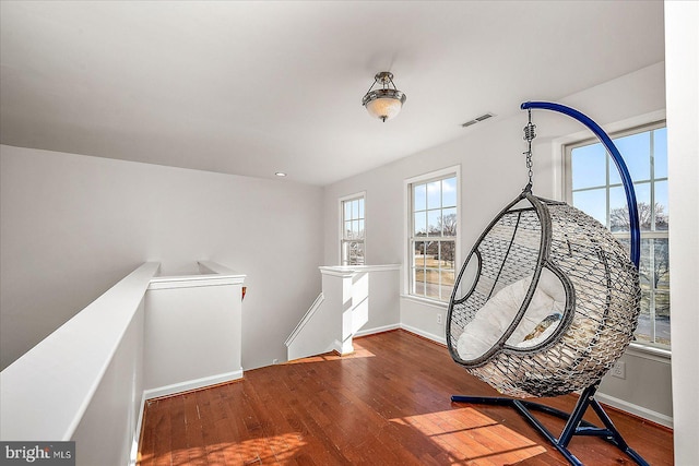 sitting room featuring visible vents, hardwood / wood-style flooring, an upstairs landing, and baseboards