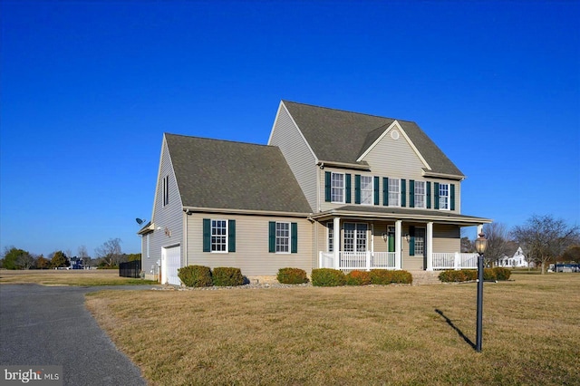 view of front of property featuring a garage, covered porch, aphalt driveway, and a front lawn