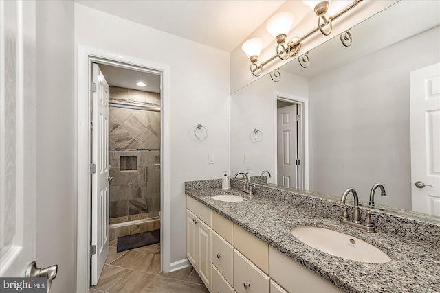 bathroom with a stall shower, a sink, and double vanity