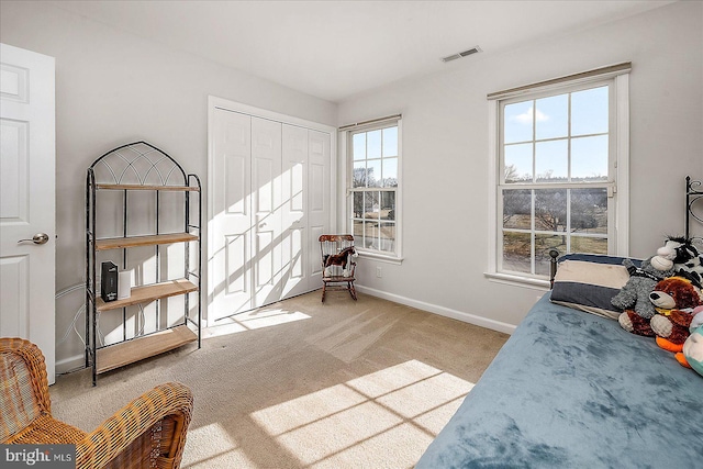 bedroom with carpet floors, a closet, visible vents, and baseboards