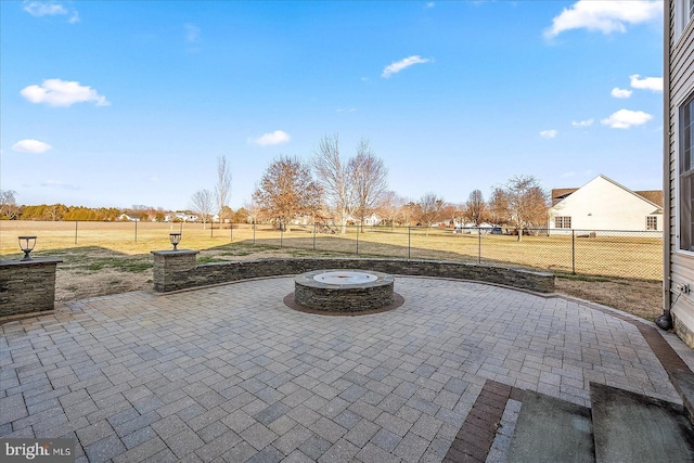 view of patio featuring fence and a fire pit