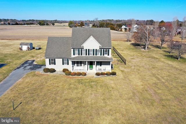 view of front of house featuring covered porch, driveway, and a front lawn